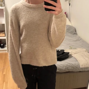 Beige stickad tröja från Soft Rebels - Helt ny Mysig beige stickad tröja från Soft Rebels. Tröjan har en rund halsringning och långa ärmar med ribbade muddar. Ull blandning. 