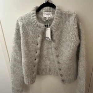 Grå cardigan från H&M - Superfin och fluffig grå kofta från NA-KD i storlek S. Den är stickad och har långa ärmar med knappar framtill. Perfekt för kyliga höst- och vinterdagar när du vill vara både varm och stilren. 🧶✨