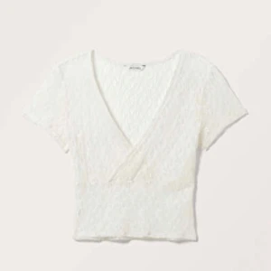 Vit spets omlottopp  - Säljer en spets omlottopp som aldrig används förutom test några gånger. Jättefin från monki och köptes för 199kr 