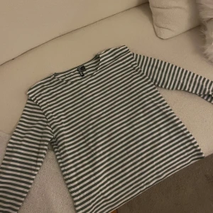 Randig långärmad tröja från Pieces - Säljer en randig långärmad tröja från Pieces i grönt och vitt. Perfekt för en avslappnad stil. Tröjan har en klassisk rund hals och är tillverkad i ett mjukt material.