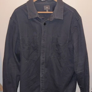 Blå Overshirt - Snygg blå overshirt från H&M premium. Passar bra till både casual och mer uppklädda tillfällen. Kostade ny 999 kr och är i mycket bra skick