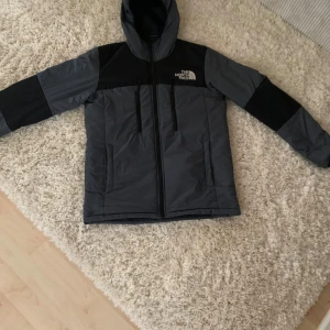 jacka från The North Face - Säljer en snygg grå och svart jacka från The North Face i storlek S. Jackan har en huva och dragkedja framtill, perfekt för kyliga dagar. Den är i mycket bra skick och passar både höst och vinter. Perfekt för dig som gillar att vara ute och upptäcka världen! 🌍för flera frågor och funderingar skicka ett sms💬 