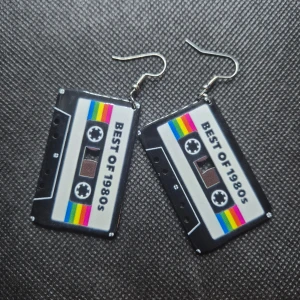 Örhängen - Kassettband 80-tal - Coola örhängen med krok, kassettband. Titta igenom alla mina upplagda & köp fler saker i Bundle för att spara på frakten & få allt du köpt i ett & samma paket✨️ För att köpa med Bundle så får du först trycka i "Köp med bundle" sedan väljer du ut allt du vill köpa för att få allt på samma frakt = Billigare 👌 Om du däremot köper fler varor i olika köp blir det egen frakt för varje köp. Önskar du swisha mej, meddela mej vad du vill köpa så ordnar vi det 👌