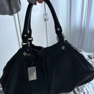 handväska från Marc by Marc Jacobs - Snygg svart handväska i skinn från Marc by Marc Jacobs. Silver detaljer och rymlig! Säljer för bäst pris!💞(pris kan diskuteras)