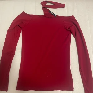 Röd offshoulder topp från BikBok - Säljer en snygg röd offshoulder topp från BikBok i storlek XS. Perfekt för festliga tillfällen med sin tighta passform och långa ärmar. 80kr +frakt 