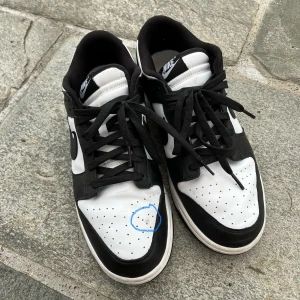 Svartvita pandas nike - Säljer ett par svartvita Nike sneakers i bra skick. De har en klassisk design med snörning och en bekväm passform. Perfekta för vardagsbruk eller träning. Några små märken finns på ovansidan, men inget som stör funktionen. Pris kan diskuteras.