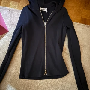 Mörkblå ribbad tröja från Weekday - Säljer en snygg mörkblå  ribbad tröja från Weekday i storlek XS. Den har en dragkedja framtill och en huva. Tröjan är i mycket bra skick och passar perfekt till höst och vår.