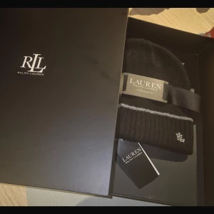 Svart mössa från Ralph Lauren - Snygg och stilren svart mössa från Ralph Lauren. Helt oanvänd med prislapp och kartong kvar. Perfekt julklapp!
