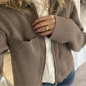 Beige stickad jacka med dragkedja - Säljer en supermysig beige stickad jacka med dragkedja framtill. Perfekt för höst och vår, med långa ärmar och en avslappnad passform. Den har praktiska fickor och är i mycket bra skick. Perfekt för en casual look! 🍂