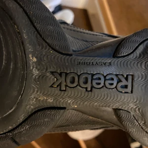 Svarta Reebok och Nike sneakers - Säljer ett par svarta Reebok sneakers med snörning och ett par svarta Nike sneakers med vit sula. Båda paren är i bra skick och perfekta för träning eller vardagsbruk. Reebok-skorna har en robust sula för extra komfort.storlek 39