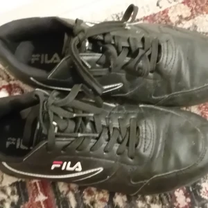 Svarta sneakers från Fila - Säljer ett par svarta Fila sneakers i bra skick. De har klassisk snörning och en stilren design med Fila-loggan på sidan. Perfekta för vardagsbruk och passar till det mesta i garderoben.