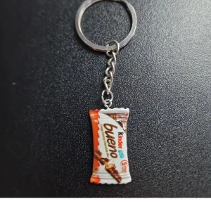 Kinder nyckelring  - Nyckelring med en miniatyr av en Kinder Bueno-förpackning. Perfekt för chokladälskare som vill ha något unikt och roligt att hänga på sina nycklar.