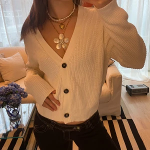 Stickad kofta - Säljer en superfin vit stickad kofta med v-ringad design och i mycket bra skick. I storlek XL men sitter som en oversized S