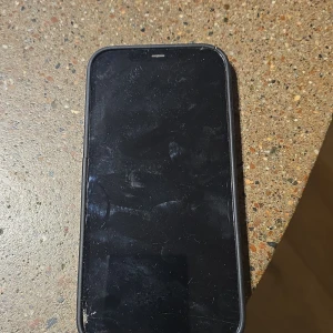 Svart iPhone med skal - Säljer en svart iPhone med ett svart skal. Telefonen har en elegant design med tre kameralinser på baksidan. Skalet är avtagbart och ger extra skydd. Perfekt för dig som vill ha en stilren och funktionell mobil. Skärmen har några repor, men inget som påverkar användningen. Passa på att fynda denna snygga telefon!