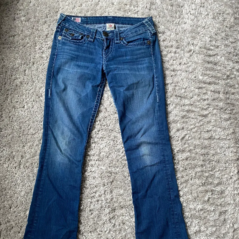 Säljer mina lågmidjade bootcut true religion jeans💕   Midjemåttet rakt över:39cm Innerbenslängden:83cm De har inga defekter förutom några få saknade sömmar längst ned på vänstra benet (se bild 5) men inget som märks!❤️  Skriv för frågor eller bilder!. Jeans & Byxor.