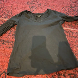 Svart långärmad tröja - Säljer en enkel och stilren svart långärmad tröja. Perfekt för både vardag och fest. Tröjan har en v-ringad hals och är i ett mjukt och bekvämt material. Passar bra till jeans eller kjol. Hör av dig vid intresse!