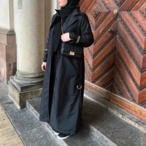 Svart trenchcoat  - Helt ny, inköpt i London  I regnkläds material, den tål regn.  Längd: 140cm, jag är 167 cm lång  Detalj: guld detalj på armarna, samt bälte  • ena  bilden är på Maria Reina, hur den sitter på henne