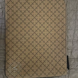 Marlene Birger datorfodral - Säljer en snygg beige datorväska med ett stilrent rutigt mönster från Marlene Birger. Väskan har en praktisk dragkedja och är perfekt för att skydda din laptop. Passar bra för både vardag och arbete.