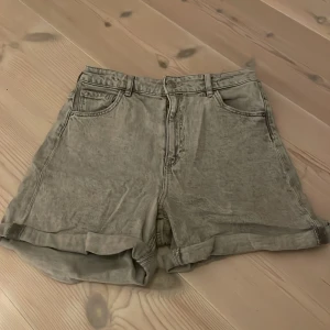 Grå denimshorts från H&M - Säljer ett par grå denimshorts från H&M i storlek 158. De är högmidjade och har en avslappnad passform. Perfekta för sommardagar! 🩳