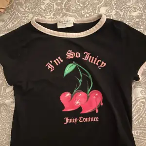 Säljer en svart t-shirt från Juicy Couture med texten 'I'm So Juicy' och ett körsbärstryck på framsidan. T-shirten har rosa detaljer vid ärmslut och halsringning. Perfekt för en casual look eller en avslappnad dag ute. Köpt för 800 kr 🖤