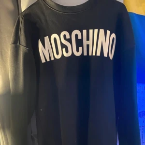 Svart sweatshirt från Moschino - Säljer en stilren svart sweatshirt från Moschino Couture! Milano. Den är gjord av 100% bomull och har en klassisk passform med långa ärmar. Perfekt för både vardag och festliga tillfällen. 🖤Bra skick och även en mycket bekväm tröja. Självklart äkta och nypris ligger runt 3000. Storlek S