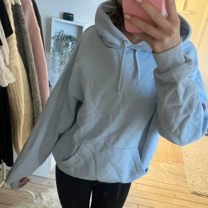 Ljusblå hoodie -  ljusblå hoodie i bra skick.  ekväma passform och stora ficka framtill. Den har en klassisk huva med ribbade muddar vid ärmslut. Bra skick men en liten fläck vid ärmen.