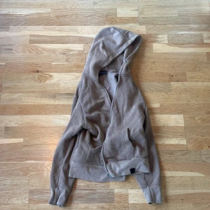 Brun/Beige hoodie från Pull&Bear - Säljer en supermjuk och skön brun/beige hoodie från Pull&Bear. Den har en dragkedja framtill och är fodrad med fleece för extra värme. Perfekt för kyliga dagar! 🧥Nypris 400:-. Tyvärr har snöret till tröjan trillat av men är lika skön för det!