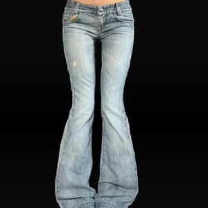Super lågmidjade bootcut jeans! - Säljer ett par snygga blå bootcut jeans. De är lågmidjade och har en slitning på ena benet. Midjemått 35cm, innerbenslängd 82cm