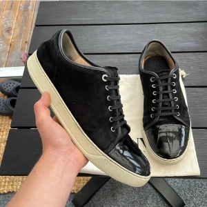 Lanvins  - Säljer ett par feta svarta lanvins med glans som alldrig kan gå fel! Storlek 45 på dessa. Skick 7/10 finns skador på framsidan av cap toen. Kan gå ner i pris vid snabb affär. Hör av dig vid minsta fundering!🤩