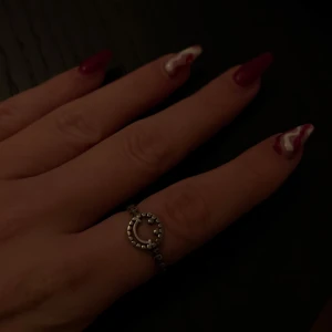 Silverfärgad ring med smiley - Cool och trendig ring i silverfärg med en smiley-design framtill. Ringen har en justerbar storlek och är perfekt för att ge en lekfull touch till din outfit. Passar både till vardags och festliga tillfällen. Passar alla då man kan anpassa den efter fingrar