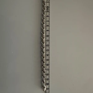 Italy 925 cordell armband - Snyggt silverarmband i flätad design med stämpel 925, vilket betyder att det är äkta silver. Armbandet har en robust känsla och en säker låsning. Perfekt för både vardag och festliga tillfällen. Längden är cirka 20 cm enligt måttbandet på bilden.