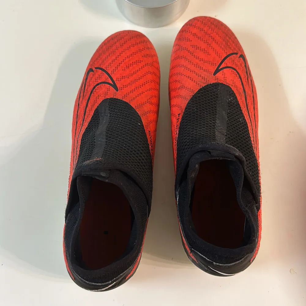 Säljer ett par röda Nike Phantom fotbollsskor i bra skick. De har en snygg svart och röd design med en tight passform och är perfekta för fotboll. Skorna har dobbar för bra grepp på planen. Ord. Pris 1200kr. Säljer för att jag sluta spela fotboll. Storlek 42.5. Skor.