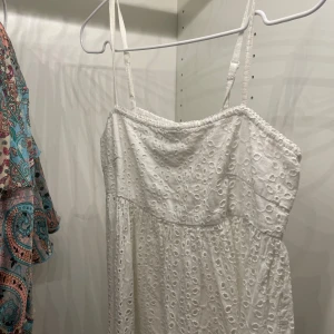 Vitt linne från Bik Bok - Söt vit klänning från Bik Bok med broderade detaljer. Den har smala axelband och en elastisk överdel för en bekväm passform. Perfekt för sommarens alla tillfällen! 🌸