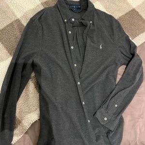 Ralph Lauren skjorta, featherweight mesh  - En grå skjorta med långa ärmar och knappar. Den har en liten polospelare-logotyp på bröstet, mesh material. Som nyskick. Har själv använt den som overshirt.