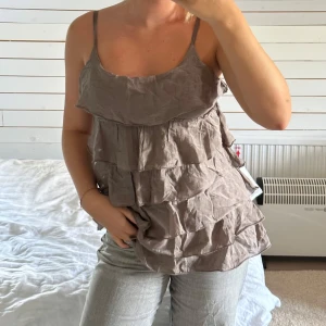 Beige volangtopp - Säljer en superfin beige volangtopp med tunna axelband. Toppen har flera lager av volanger. Står tyvärr varken märke eller storlek. Men jag är vanligtvis storlek 36-38🥰