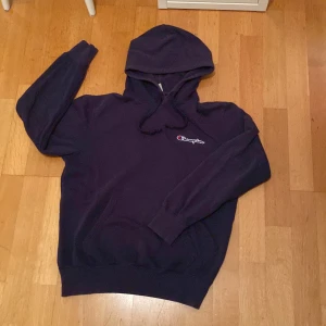 Mörkblå hoodie från Champion - Säljer en snygg mörkblå hoodie från Champion i storlek 176 (S). Den är i bra skick och perfekt för både höst och vår.