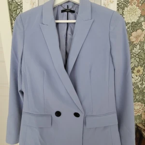 Esprit ljusblå kavaj, storlek 34 - En snygg ljusblå/ blålila kavaj med dubbla knappar framtill. Kavajen har en lite oversize passform och är perfekt för både vardag och fest. Passar även en 36:a. Nypris ca 1300kr.