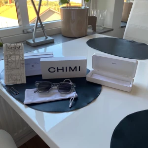 Transparenta solglasögon från Chimi - Säljer ett par snygga transparenta solglasögon från Chimi. De har en modern och stilren design med fyrkantiga bågar och mörka linser. Perfekta för sommaren och våren. Kommer med originalförpackning och fodral. Tveka inte på att kontakta mig om ni har frågor!