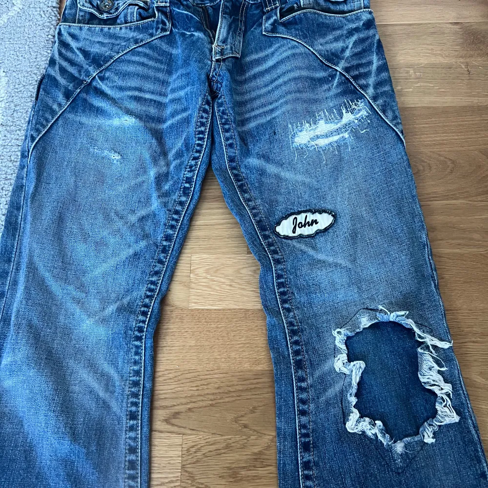 Blå Lågmidjade bootcut jeans med detaljer på. Jeans & Byxor.