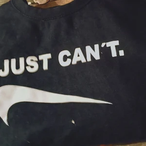 Svart t-shirt med tryck - Säljer en svart t-shirt med ett humoristiskt tryck 'I JUST CAN'T'. Perfekt för en avslappnad stil eller som statement-plagg. T-shirten är i bra skick och har en normal passform. Passar perfekt till jeans eller shorts för en cool look.