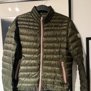 Olivgrön pufferjacka från Moncler - Hej, säljer min sjukt snygga Moncler Daniel som är perfekt nu till hösten och vintern. Cond 9/10, med en lite flaw på ryggen(se bild). Size 2. Kom provat vid fler frågor!🎃