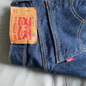Levi's 501 Jeans - Säljer ett par Levi's 501 jeans i mörkblå denim. De är raka i passformen. Perfekta för både vardag och fest! Jeansens midja är midwaist och de har en traditionell knappgylf. Levi's endast använda typ en gång. Storlek är 34 i waist men passar 32