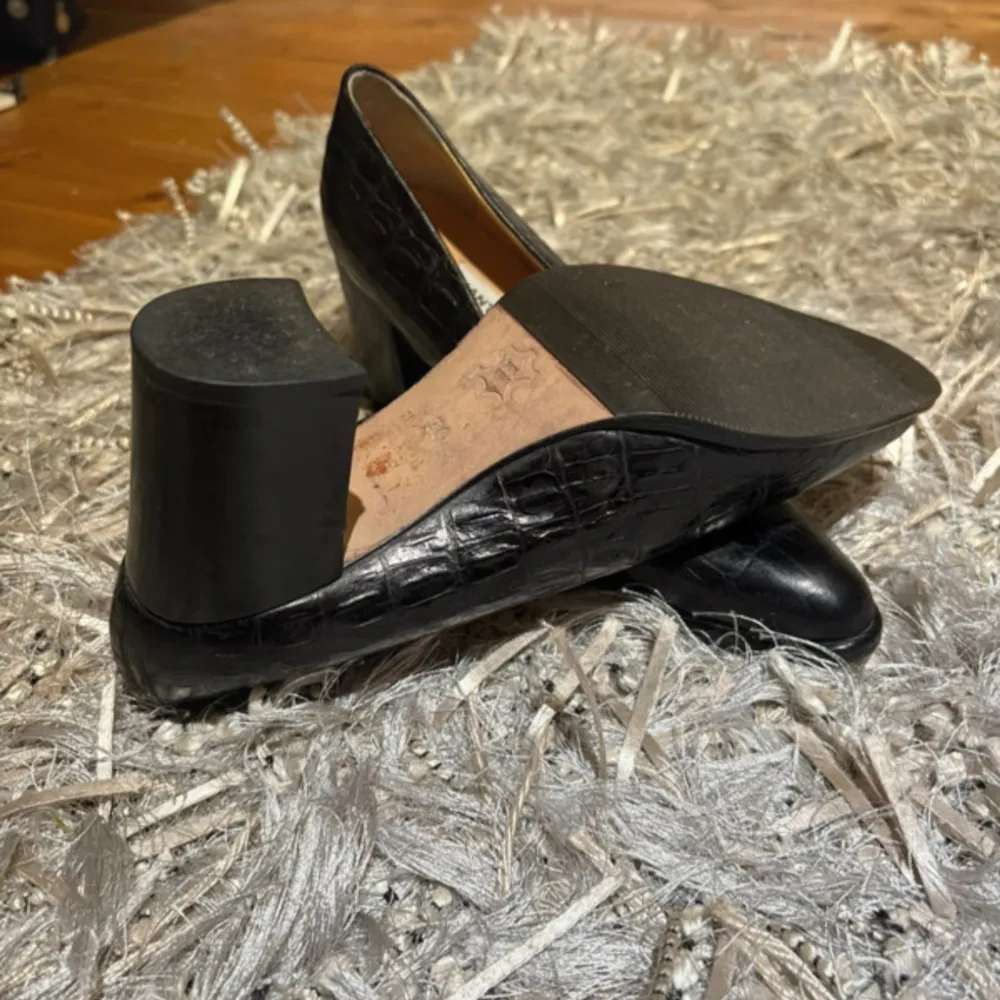 Säljer ett par eleganta svarta pumps med ett coolt krokodilmönster. Skorna är lite stora i storleken är 36 men passar ej mig som bara har 36. Kengät.