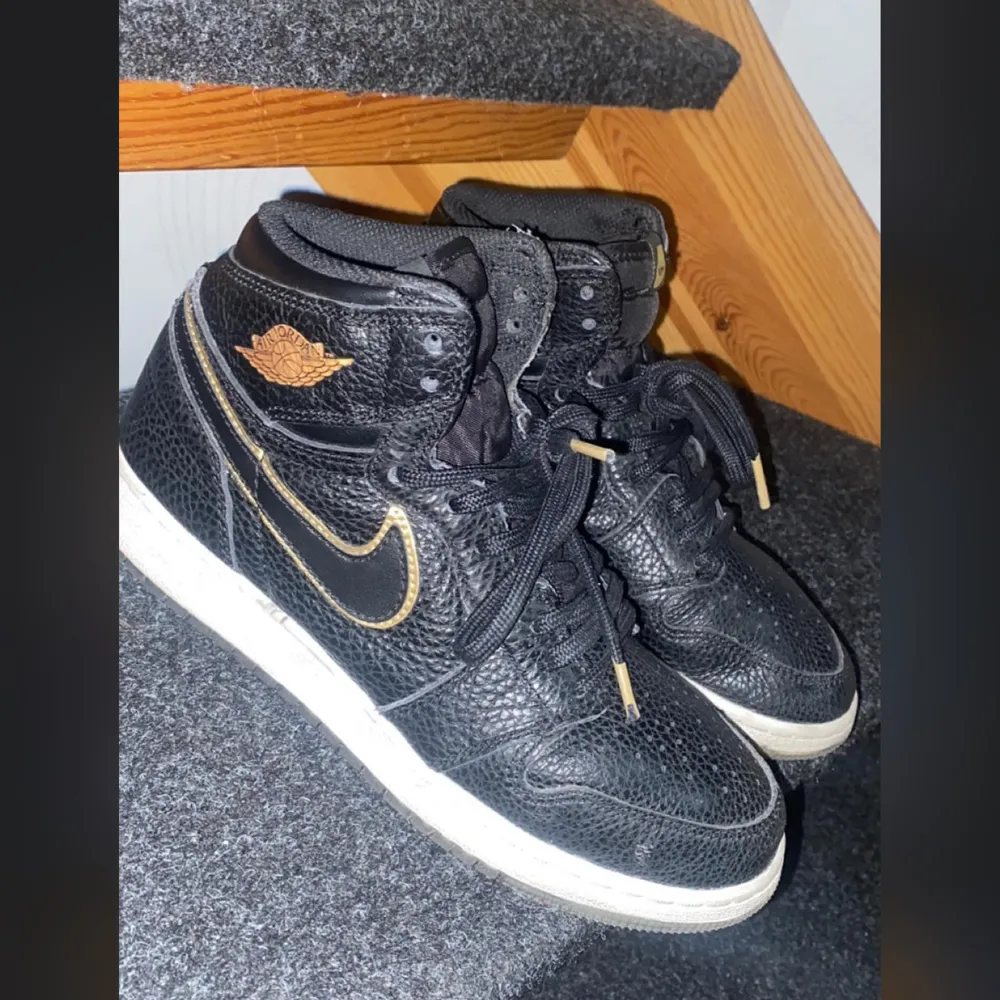 Säljer ett par snygga svarta Nike Air Jordans i storlek 39. Air Jordan 1 retro high og CIty of Flight.Skorna har coola gulddetaljer och är i nyskick. Säljer ett par snygga svarta Nike Air Jordans i storlek 39, är i nyskick.. Skor.