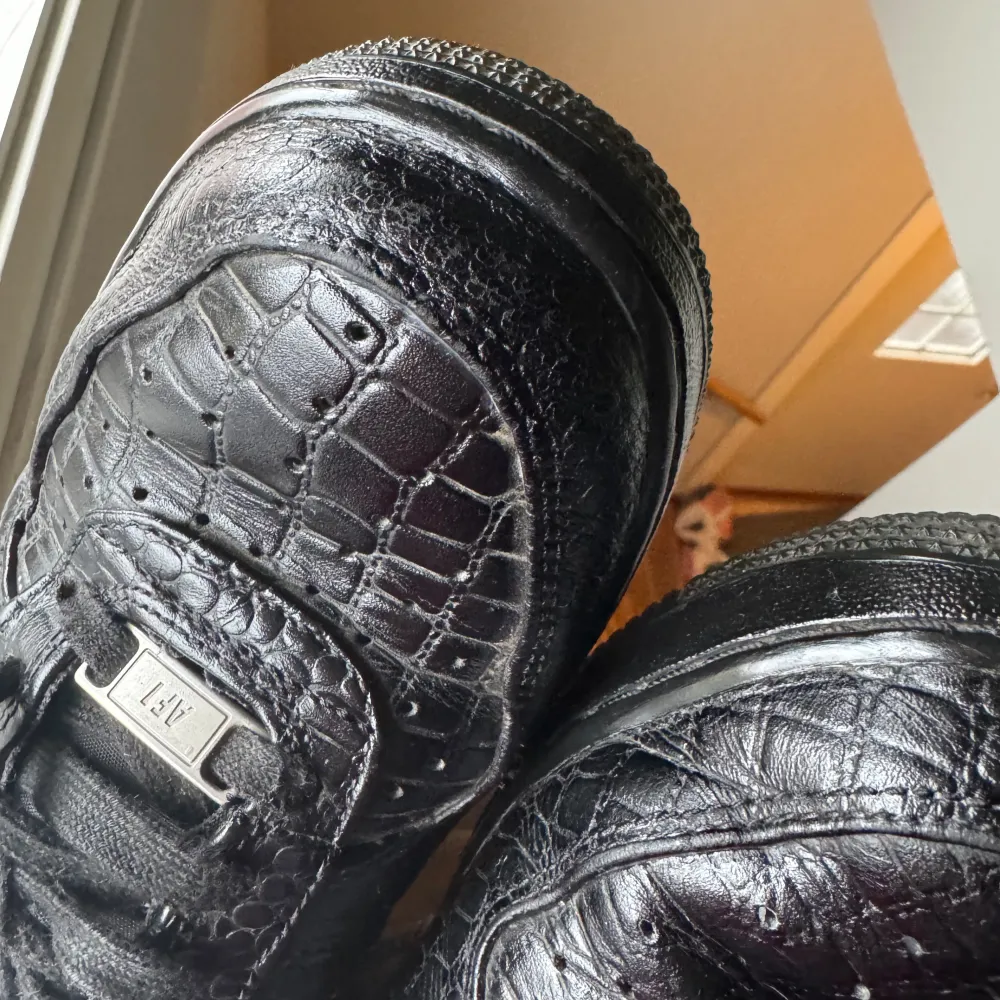 Svarta Nike airforce 1 black croc som modellen heter. Dom är inte i det nyaste skicket då de är slitna fram och lite på sidan. Jag ser att dom säljs till ett betydligt högre pris andra ställen så lägger mig mycket bra under med 150kr. Str 39. Skor.