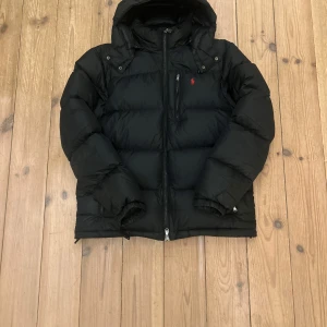 Ralph Lauren Jacka  - Vinterns hetaste jacka! Storlek large. Jackan är i fint skick förutom litet hål i högrar ärmen. Nypriset på en sån jacka är runt 5,5 tusen, priset är ej hugget i Sten. Hör av dig vid minsta lilla fråga!