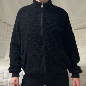 Fluffig svart jacka - Säljer denna svarta jacka från Vailent i storlek M! Den är reversible och kan därför både bäras fluffet utåt och inåt. Obs! Mindre hål i fickorna❤️
