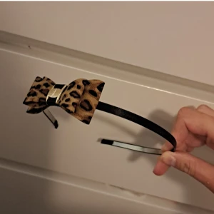 Leopardmönstrat diadem med rosett - Snyggt diadem med leopardmönstrad rosett. Perfekt för att ge din outfit en extra touch! Diademet är smalt och bekvämt att bära hela dagen.