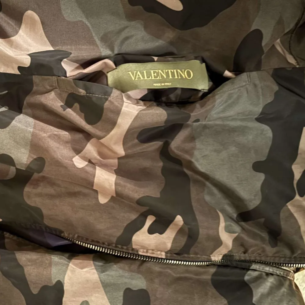 Valentino Garavani Windbreaker som är varsamt använd, mycket bra skick. Cond: 10/10.  Två olika färger, mörkblå- och grön kamouflage. Vändbar. 100% polyester.  Jag på bilden är 184kg och 78kg. Passar en storlek M men även en ”liten large”.  . Jackor.