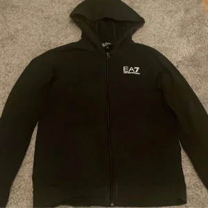 Svart ziphoodie från EA7 - Svart zip hoodie från EA7 köpt för ungefär 900kr men inte använd så mycket därför säljs den. 